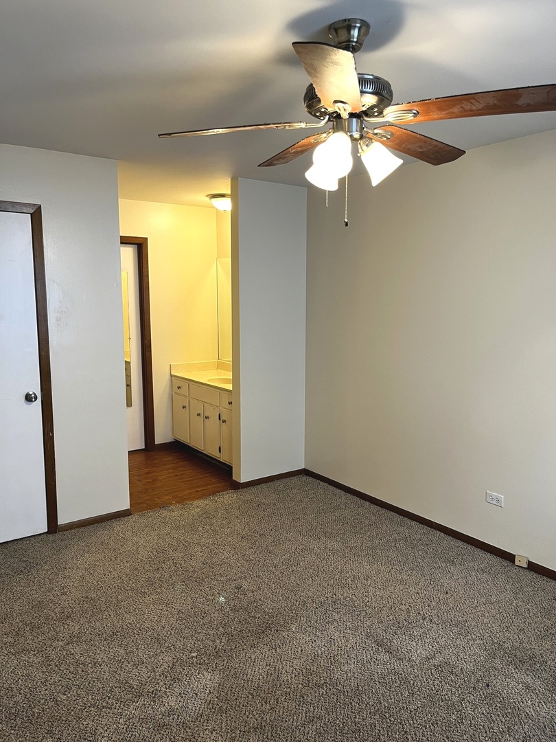 18430 Aberdeen Street Homewood, IL 60430 - Photo 7 of 13 an empty room with a chandelier fan and windows