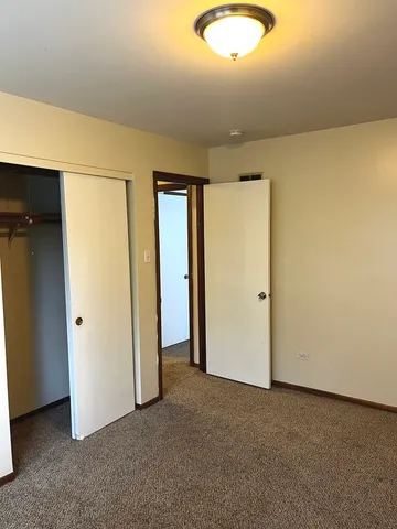 an empty room with closet and mirrors