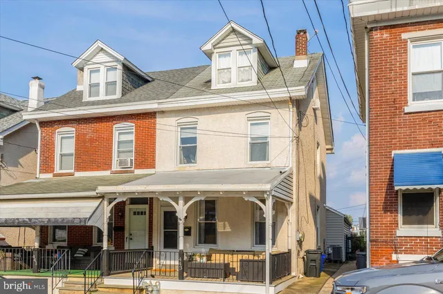 a front view of a residential apartment building with a clock on the wall