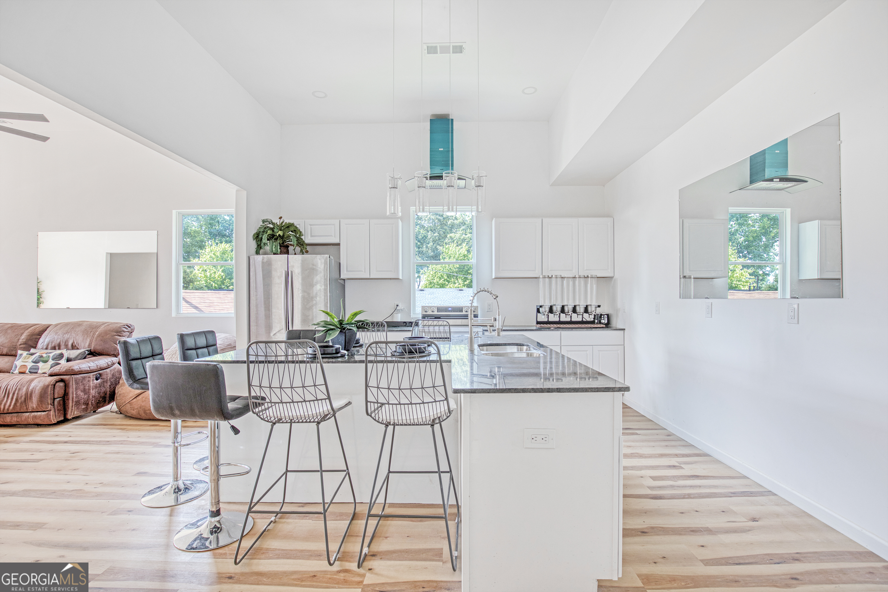 235 Candler Road Southeast Atlanta, GA 30317 - Photo 8 of 26 a kitchen with stainless steel appliances kitchen island granite countertop a stove a sink and white cabinets with wooden floor