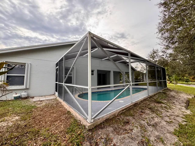 a large white kitchen with a refrigerator a stove top oven and a sink