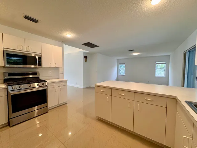 a kitchen with stainless steel appliances a stove sink and microwave