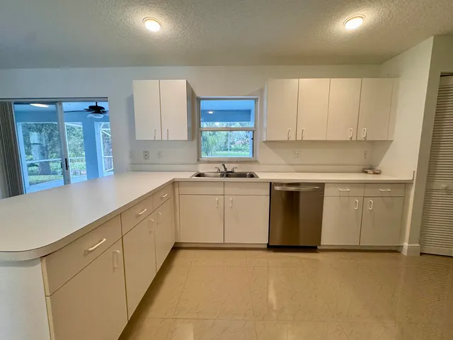 a kitchen with granite countertop white cabinets and white appliances
