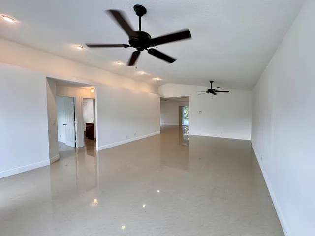 wooden floor in an empty room with a ceiling fan