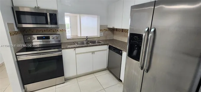 a kitchen with stainless steel appliances a stove a microwave and a refrigerator