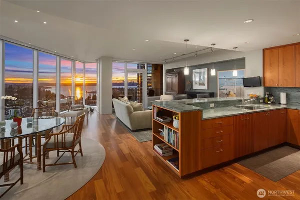 a kitchen with stainless steel appliances granite countertop a stove top oven a dining table and chairs