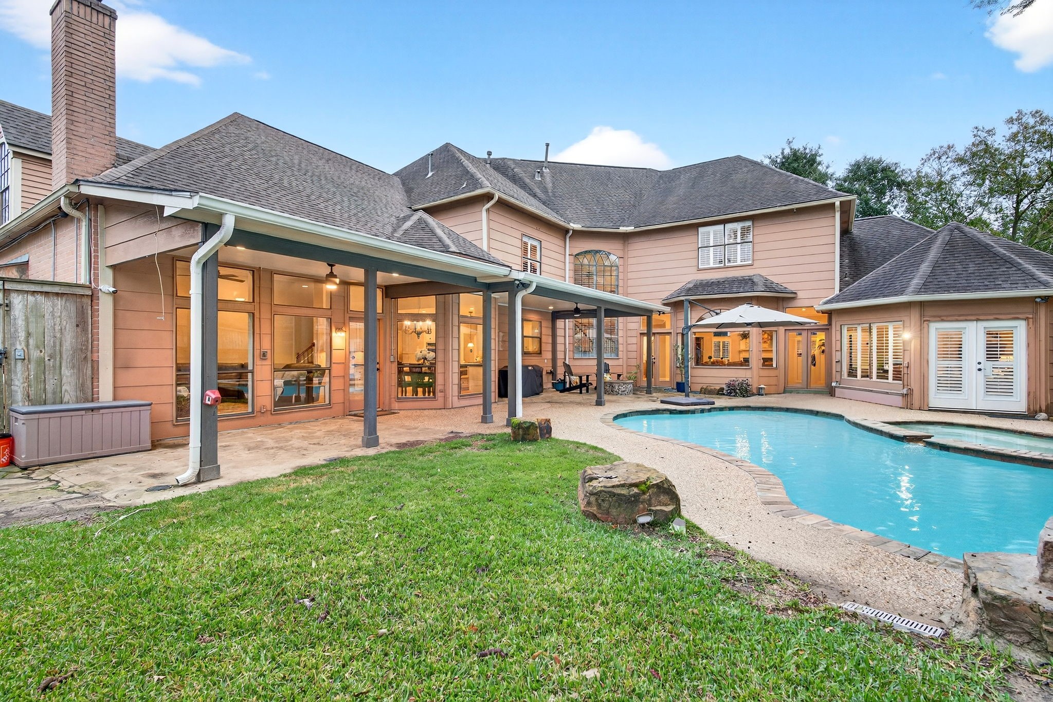 20006 Gable Point Drive Katy, TX 77450 - Photo 39 of 44 a view of a house with pool and a yard with table and chairs under an umbrella