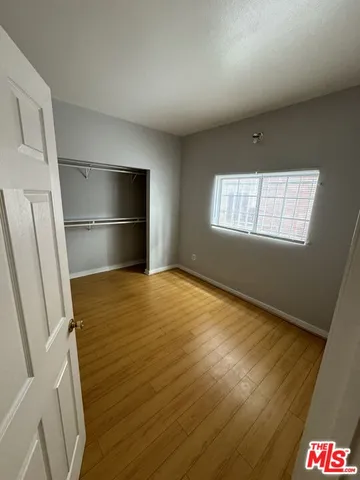 a view of empty room with window and wooden floor