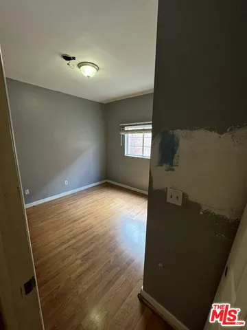 en empty room with wooden floor and windows