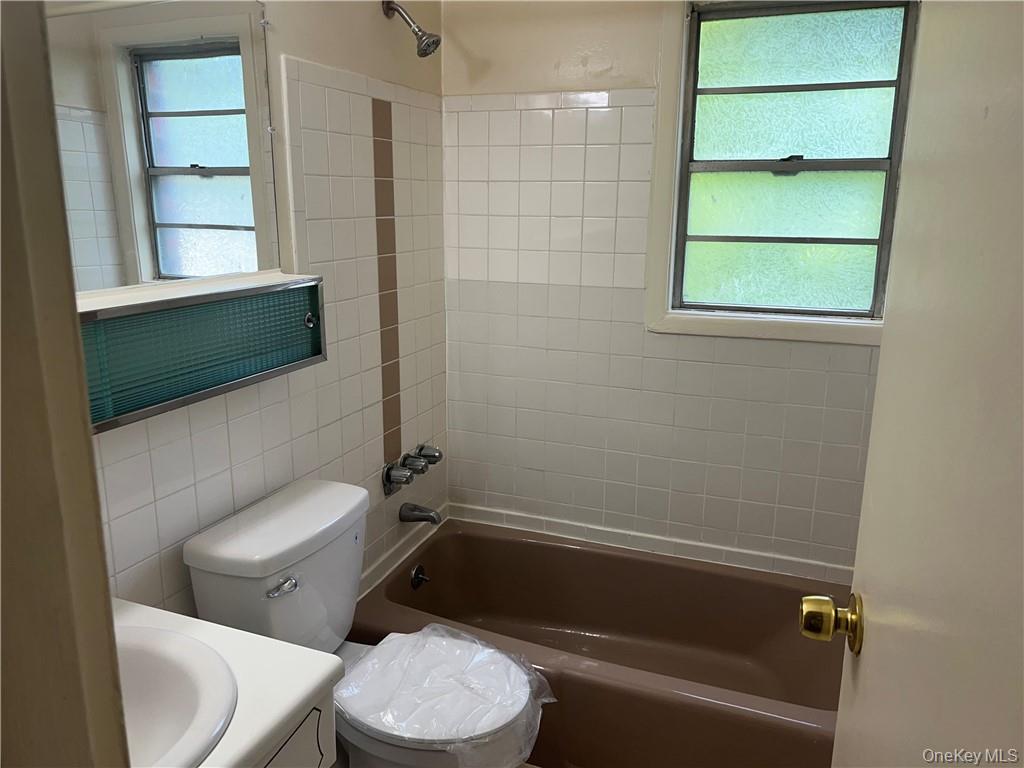 65 Curie Road, Unit G7 Cornwall-on-Hudson, NY 12520 - Photo 12 of 12 a white toilet sitting next to a bathroom sink and tub