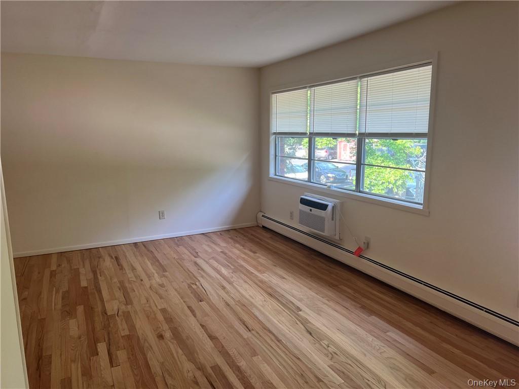 65 Curie Road, Unit G7 Cornwall-on-Hudson, NY 12520 - Photo 7 of 12 an empty room with wooden floor and windows