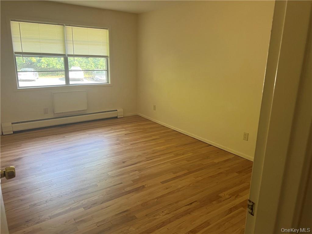 65 Curie Road, Unit G7 Cornwall-on-Hudson, NY 12520 - Photo 10 of 12 an empty room with wooden floor and windows