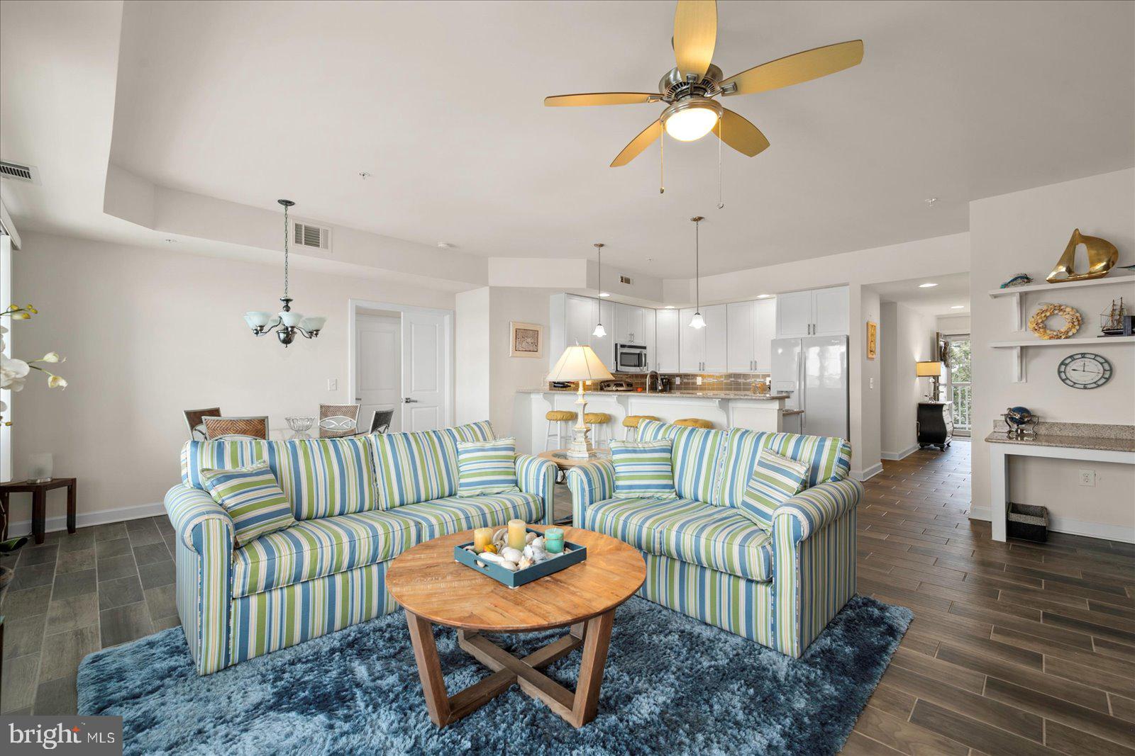 37292 Lighthouse Road, Unit 202 Selbyville, DE 19975 - Photo 14 of 78 a living room with furniture and a dining table with wooden floor