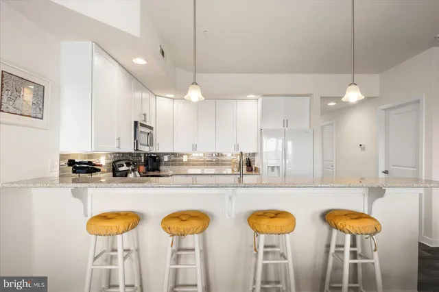 a kitchen with stainless steel appliances granite countertop a sink a stove and a refrigerator