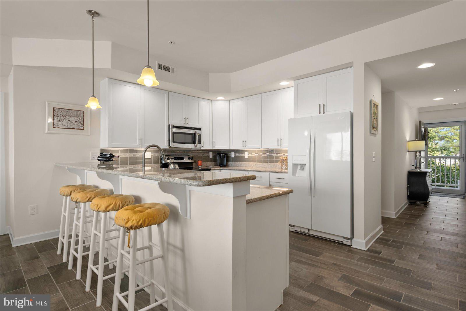 37292 Lighthouse Road, Unit 202 Selbyville, DE 19975 - Photo 17 of 78 a kitchen with stainless steel appliances granite countertop a refrigerator a stove top oven a sink dishwasher and a refrigerator