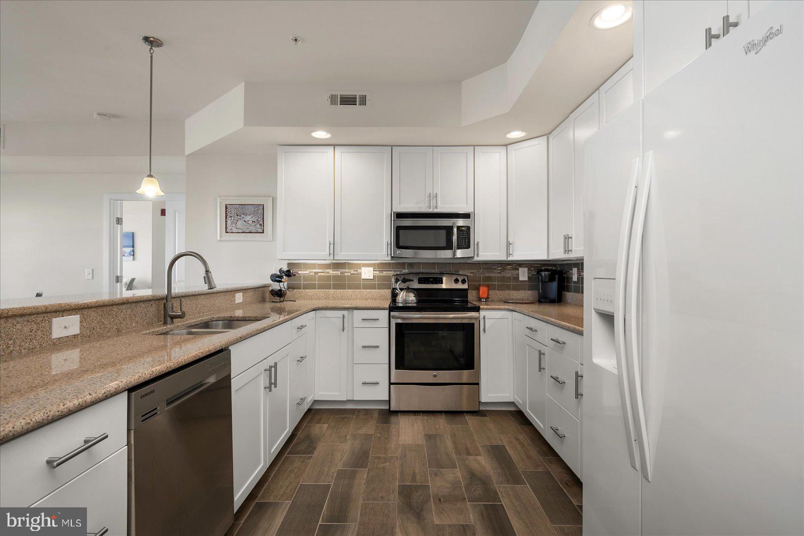 37292 Lighthouse Road, Unit 202 Selbyville, DE 19975 - Photo 19 of 78 a kitchen with stainless steel appliances granite countertop a sink a stove and a refrigerator