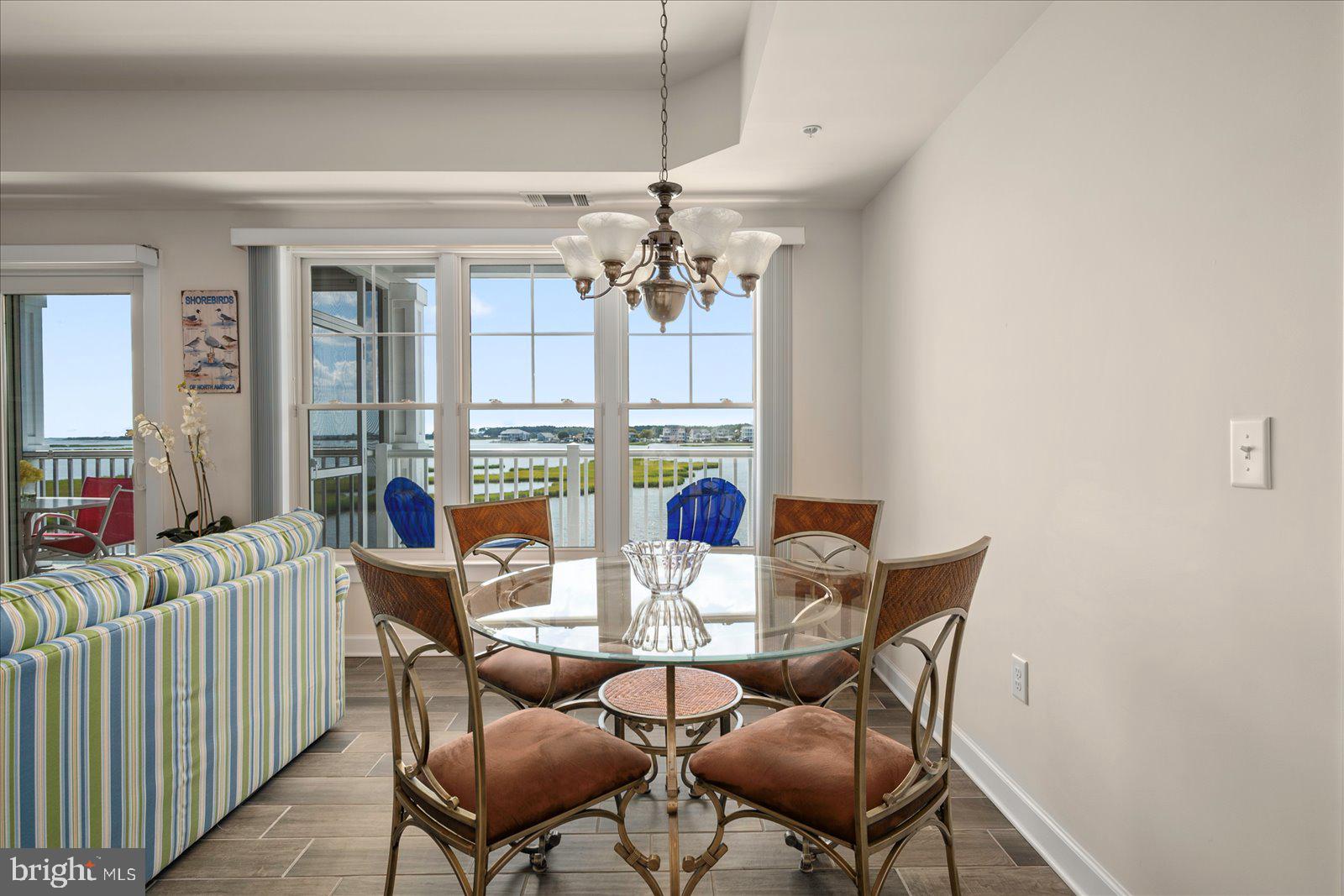 37292 Lighthouse Road, Unit 202 Selbyville, DE 19975 - Photo 22 of 78 a view of a dining room with furniture a chandelier and wooden floor
