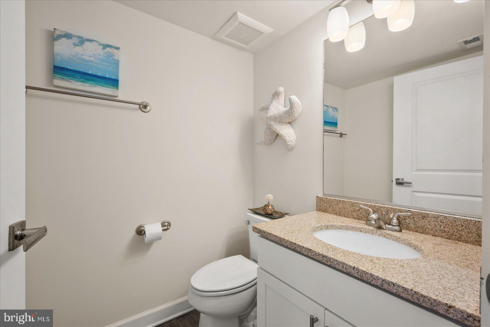 37292 Lighthouse Road, Unit 202 Selbyville, DE 19975 - Photo 25 of 78 a bathroom with a granite countertop sink mirror vanity and toilet