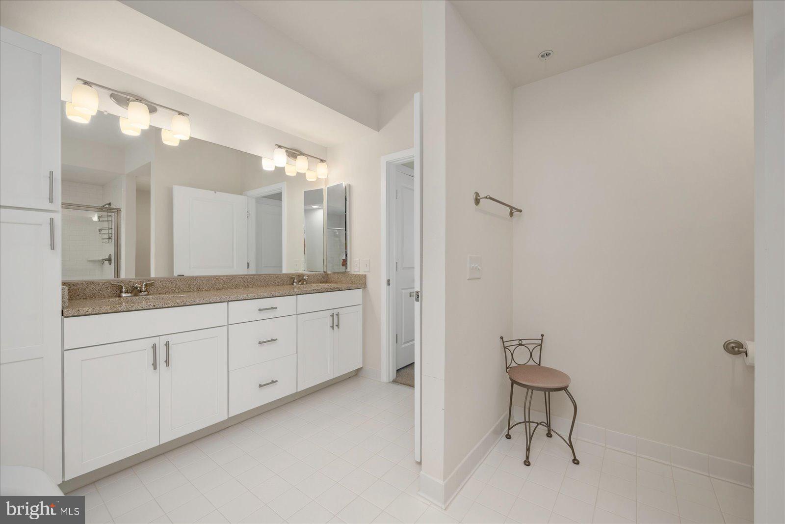 37292 Lighthouse Road, Unit 202 Selbyville, DE 19975 - Photo 33 of 78 a spacious bathroom with a granite countertop sink a toilet and a mirror
