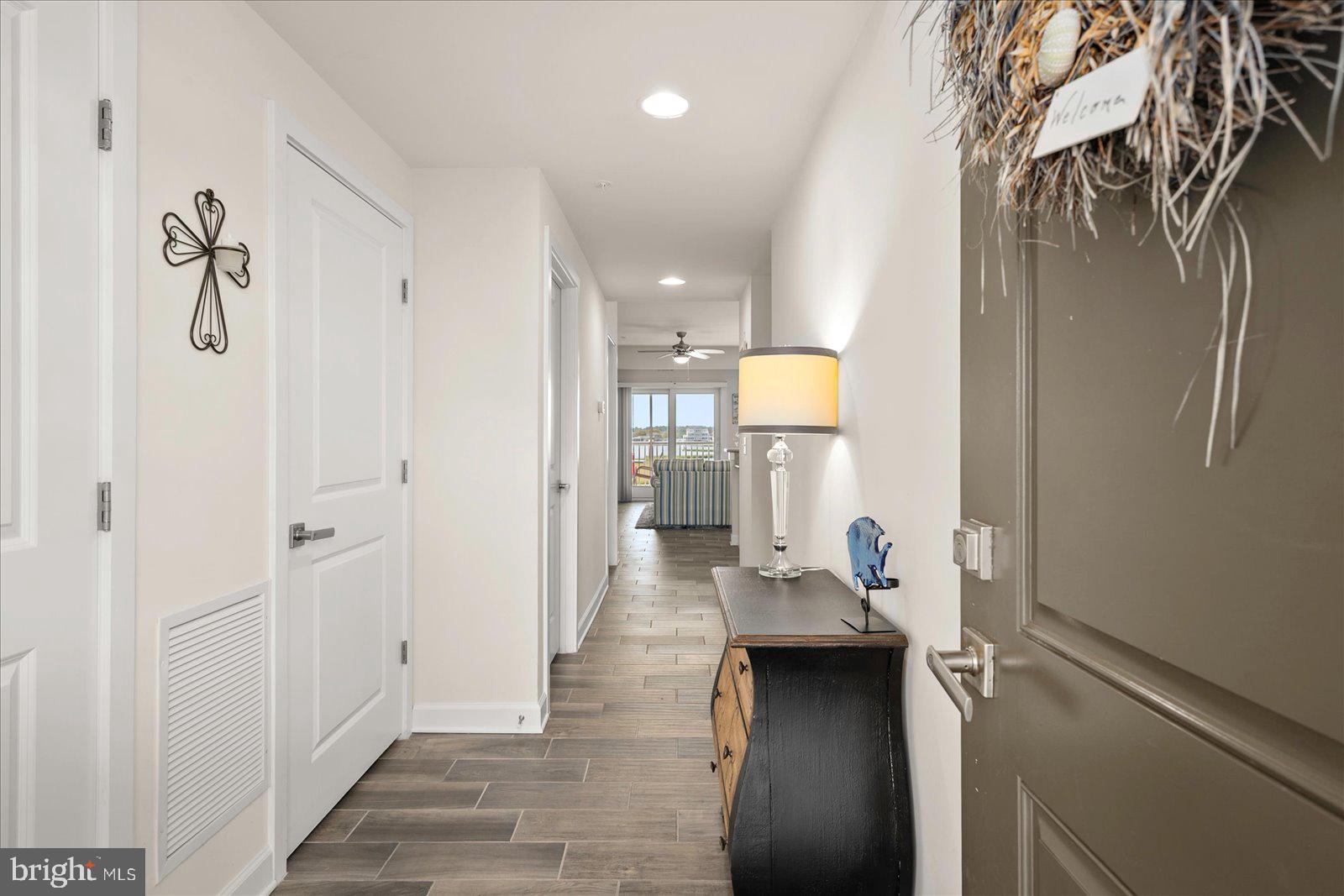 37292 Lighthouse Road, Unit 202 Selbyville, DE 19975 - Photo 4 of 78 a hallway with white doors wooden floor and glass door