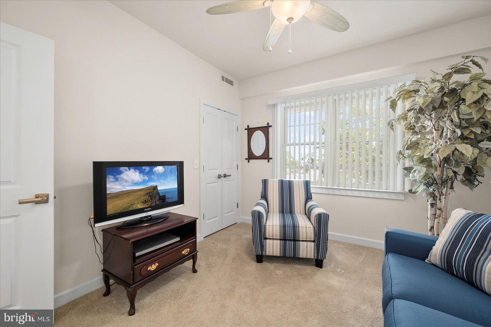37292 Lighthouse Road, Unit 202 Selbyville, DE 19975 - Photo 43 of 78 a living room with furniture a flat screen tv and a window