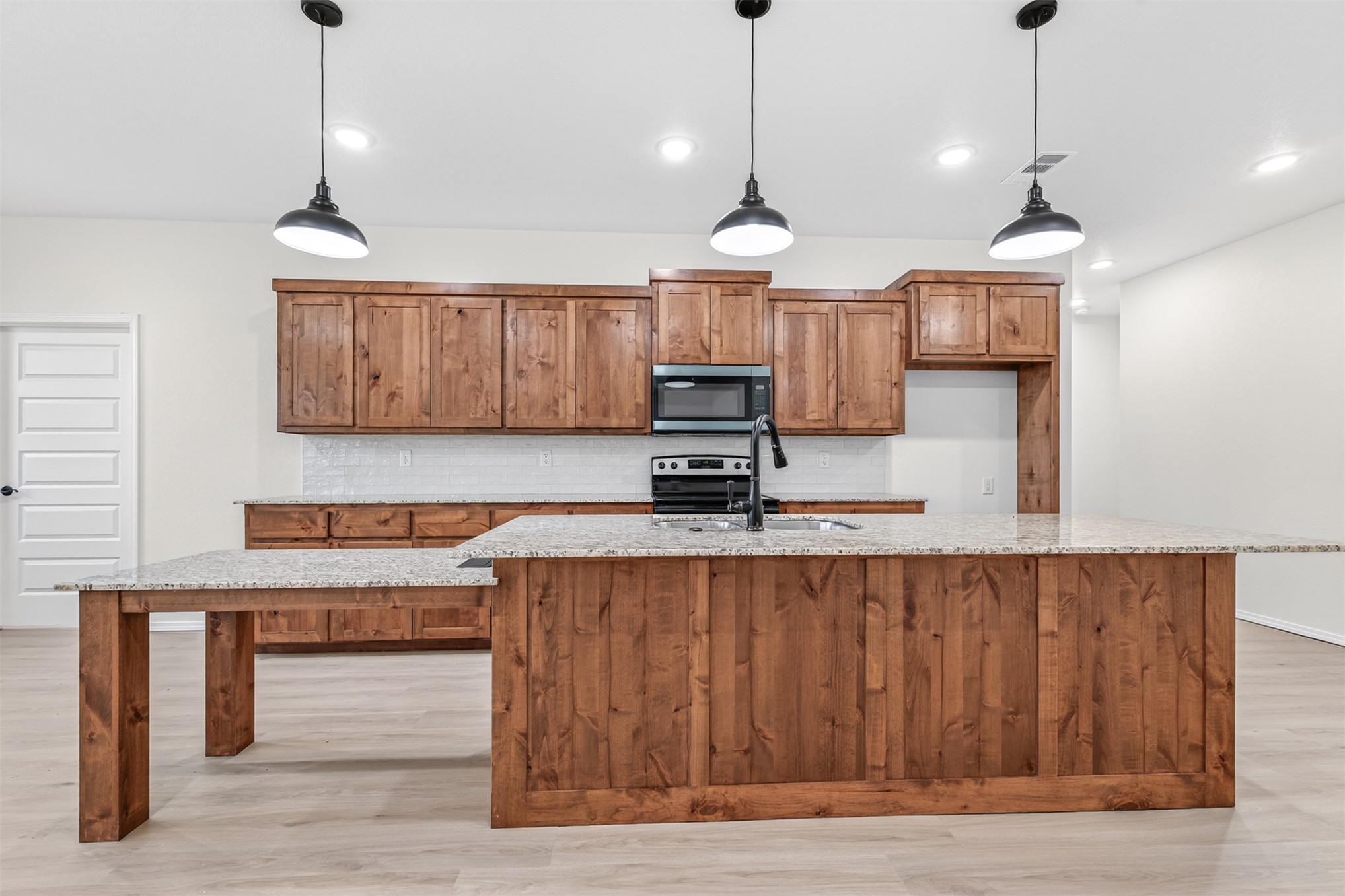 124 Countryside Way Pocola, OK 74902 - Photo 19 of 39 Spacious kitchen featuring wood-finish cabinetry, granite countertops, a built-in microwave, and a subway tile backsplash