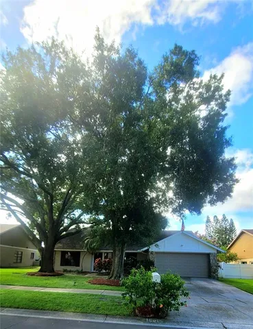 a front view of a house with a yard and trees