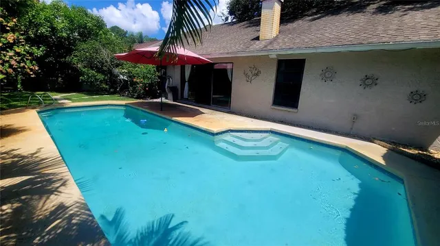 a swimming pool with outdoor seating yard and barbeque oven