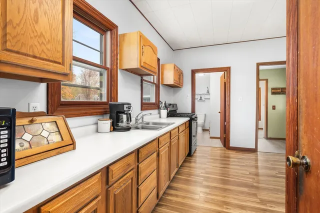 a kitchen with stainless steel appliances granite countertop a sink and a stove next to a large window