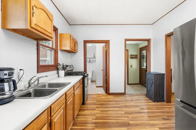 a kitchen with stainless steel appliances granite countertop a sink and dishwasher refrigerator a microwave oven with wooden floor