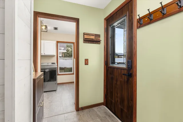 a view of a hallway with wooden floor and a bathroom