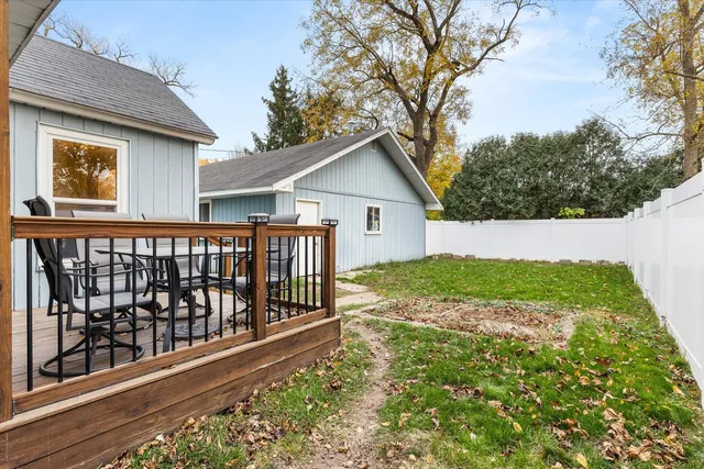 a view of a house with a small yard and wooden fence