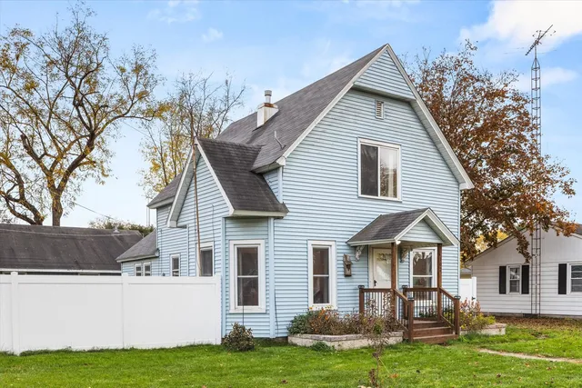 a white house that has tree in front of it