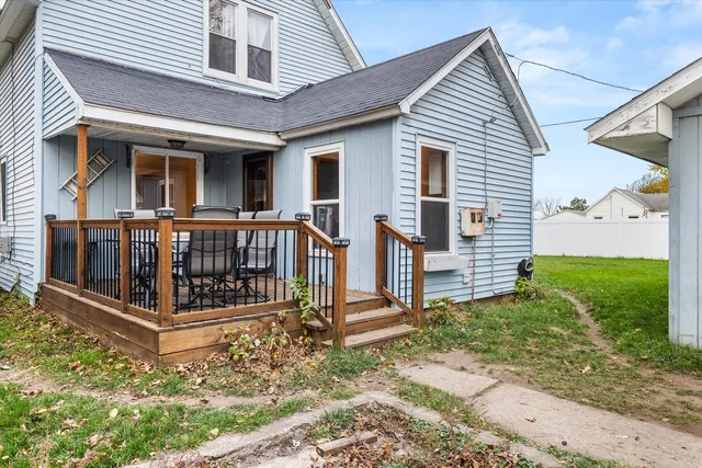 a view of a house with wooden fence next to a yard