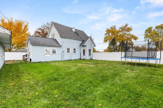 a view of a house with a big yard and a large tree