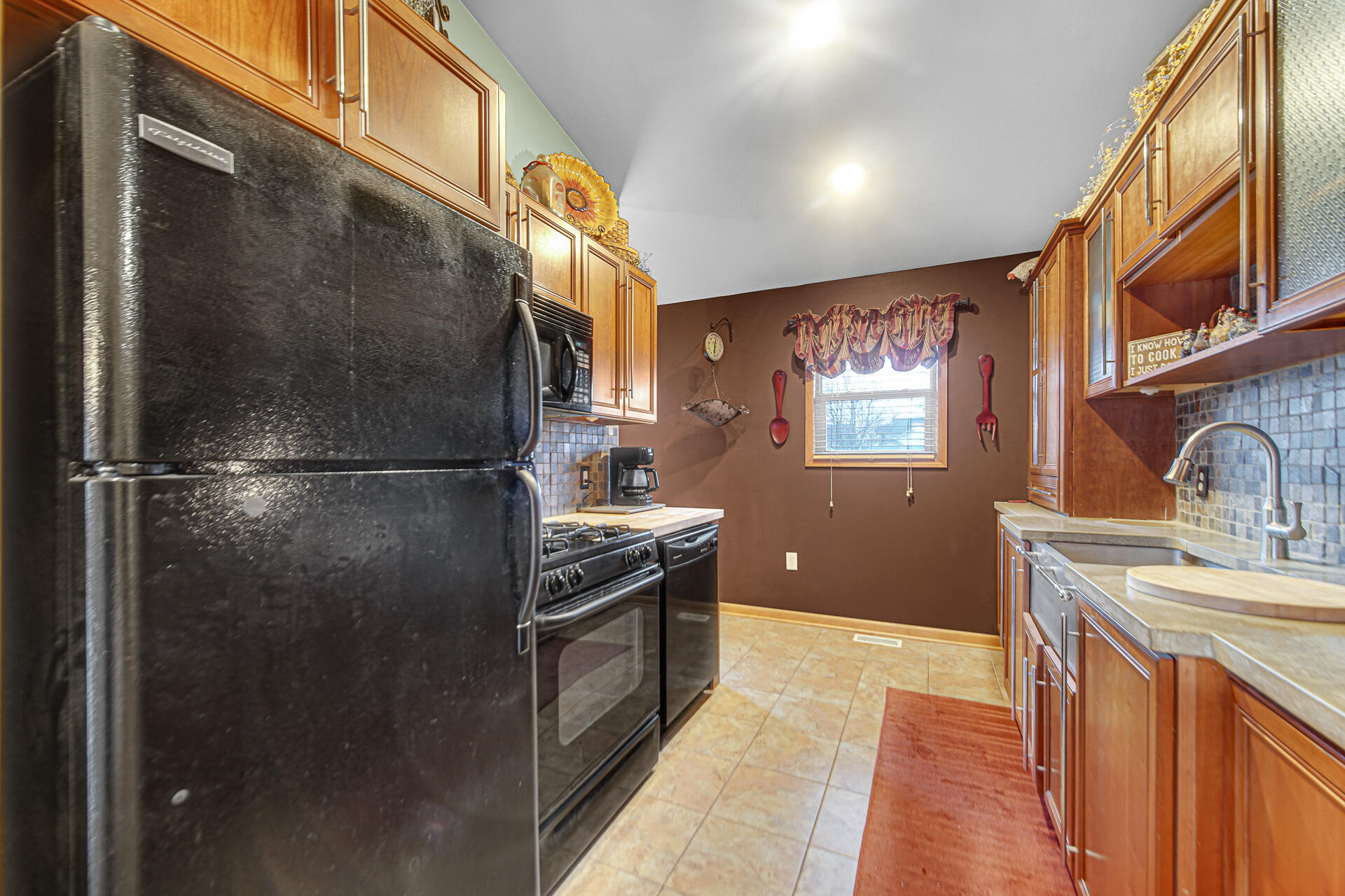 505 North Washington Street Hebron, IN 46341 - Photo 12 of 27 a kitchen with stainless steel appliances granite countertop a refrigerator a sink dishwasher a stove with wooden cabinets and floor