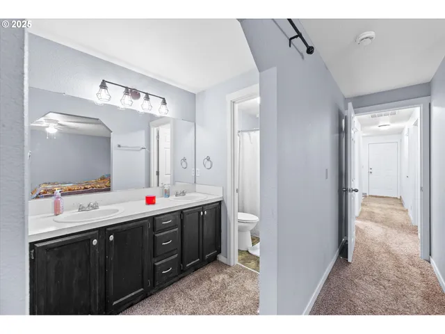 a bathroom with a sink vanity granite tub and a mirror