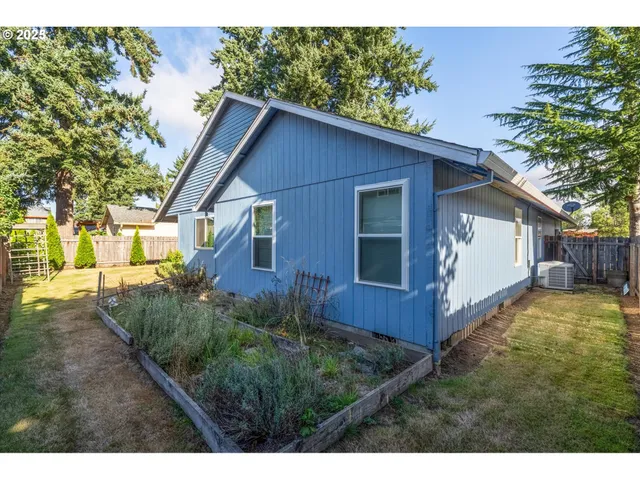a view of backyard of house with wooden fence