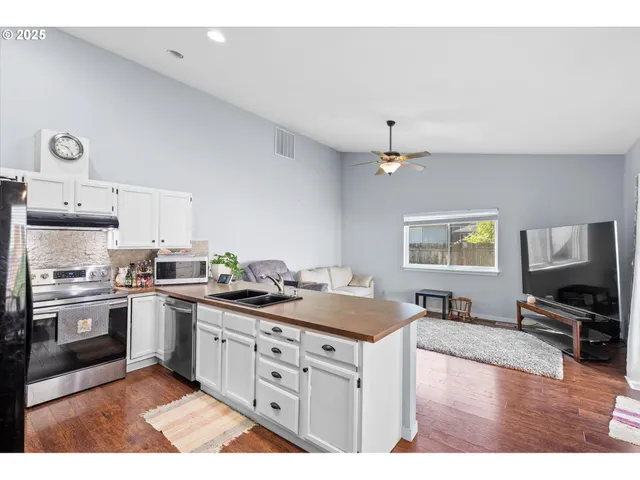 a kitchen with stainless steel appliances granite countertop a stove sink and cabinets