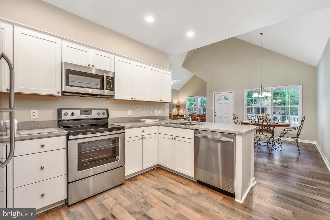173 Sandyhook Road Ocean Pines, MD 21811 - Photo 26 of 40 a kitchen with stainless steel appliances granite countertop a stove a sink a microwave a window and white cabinets