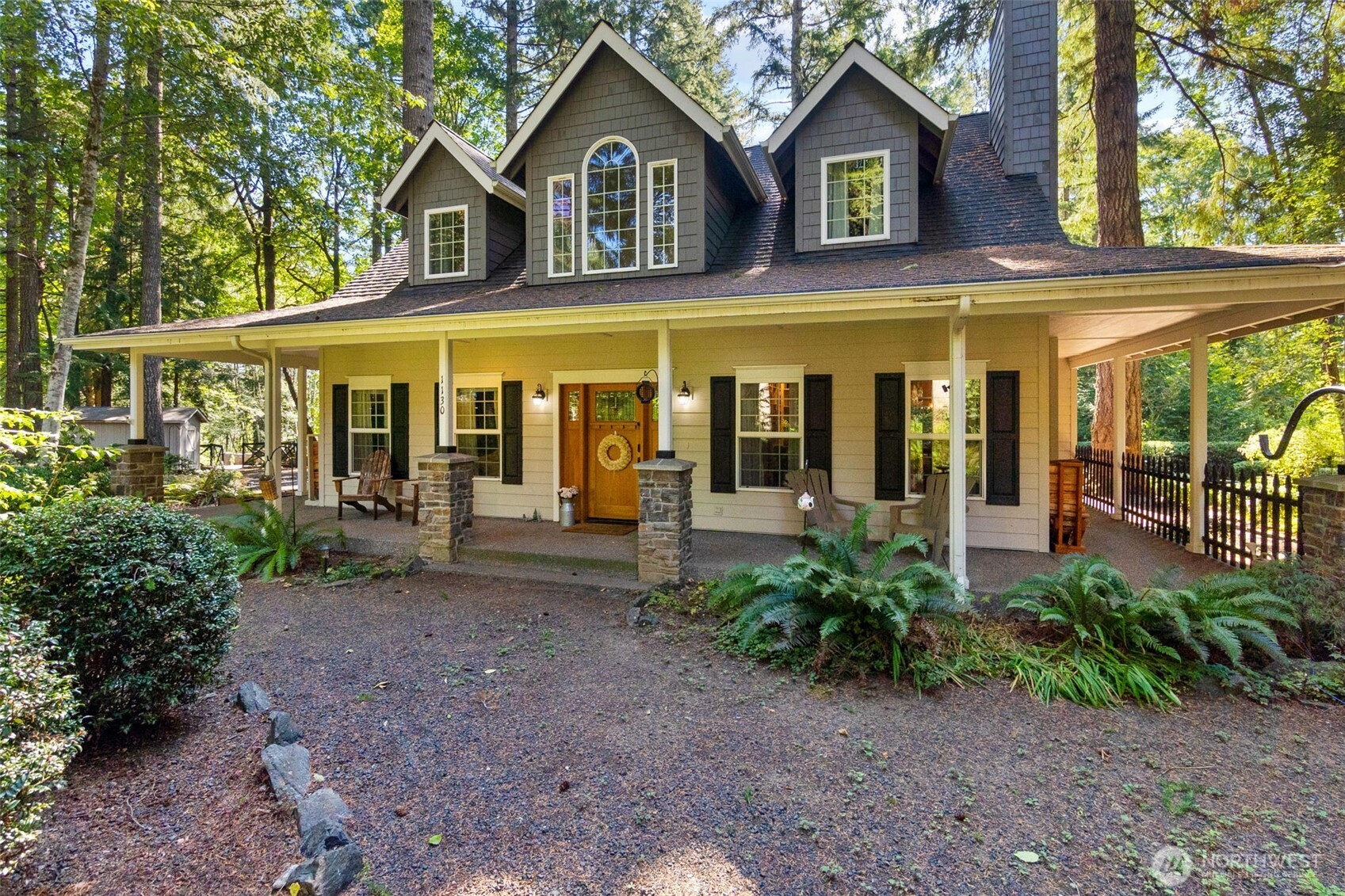 1130 East Sunset Hill Road Shelton, WA 98584 - Photo 2 of 40 a view of a brick house with large windows and a small yard