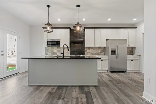 an empty room with wooden floor fireplace and windows