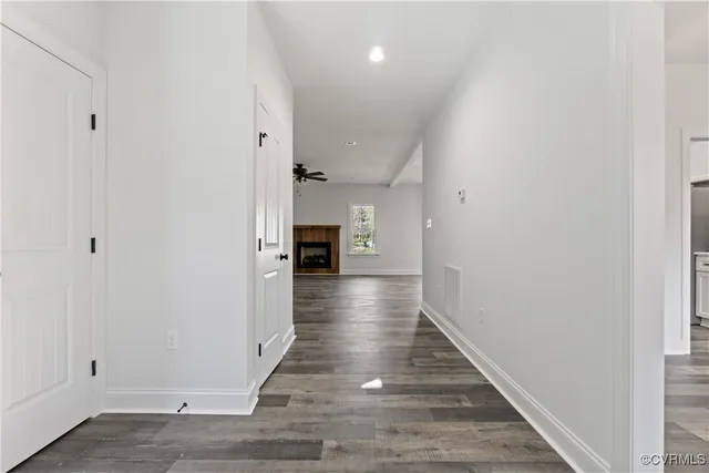 a view of an empty room with wooden floor and chandelier