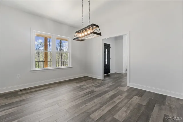 a kitchen with stainless steel appliances kitchen island granite countertop a stove top oven a refrigerator a sink and dishwasher with wooden floor