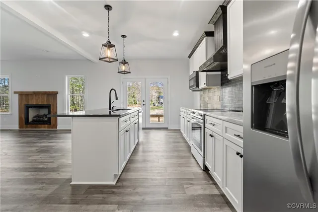 a kitchen with stove and wooden floor