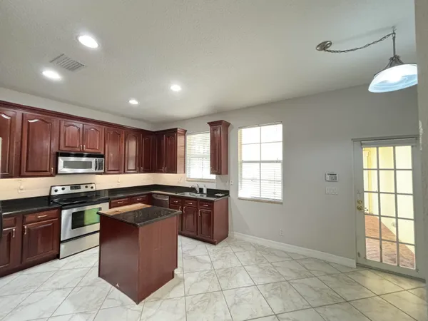 a kitchen with stainless steel appliances granite countertop a stove a refrigerator and a sink