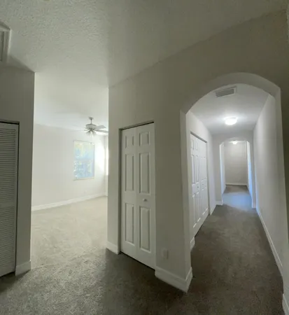 an empty room with a ceiling fan and window