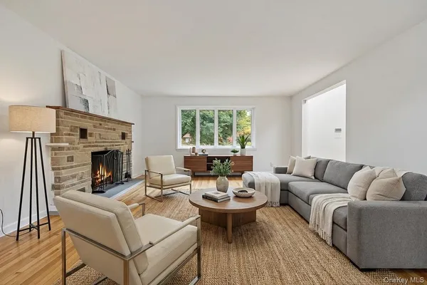 a living room with furniture a large window and a fireplace