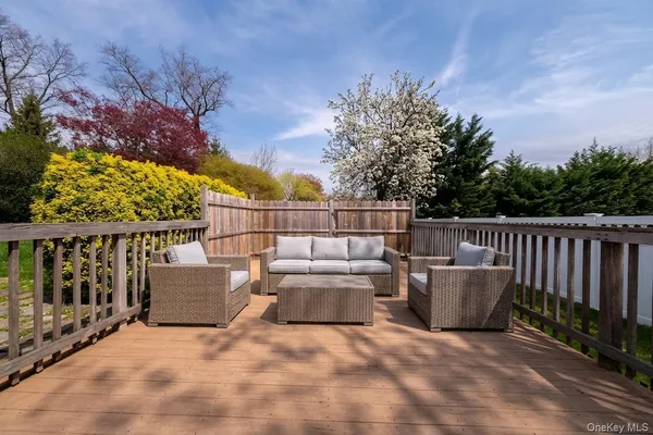 a view of roof deck with couches and wooden fence