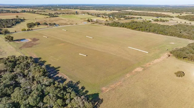an aerial view of ocean and residential houses with outdoor space
